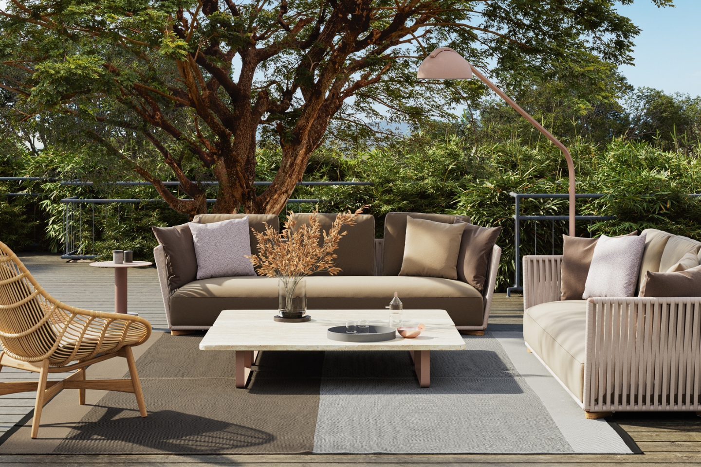 Eine stilvolle Chillout-Area im Freien mit gemütlichen Sofas in neutralen Tönen, einem niedrigen Couchtisch mit Dekoration, einem Rattanstuhl und einer eleganten Stehlampe. Die Sitzecke befindet sich auf einer Holzterrasse, umgeben von dichter grüner Vegetation und einem großen Baum, der Schatten spendet.